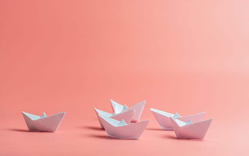 teens playing with paper boats on a rainy day